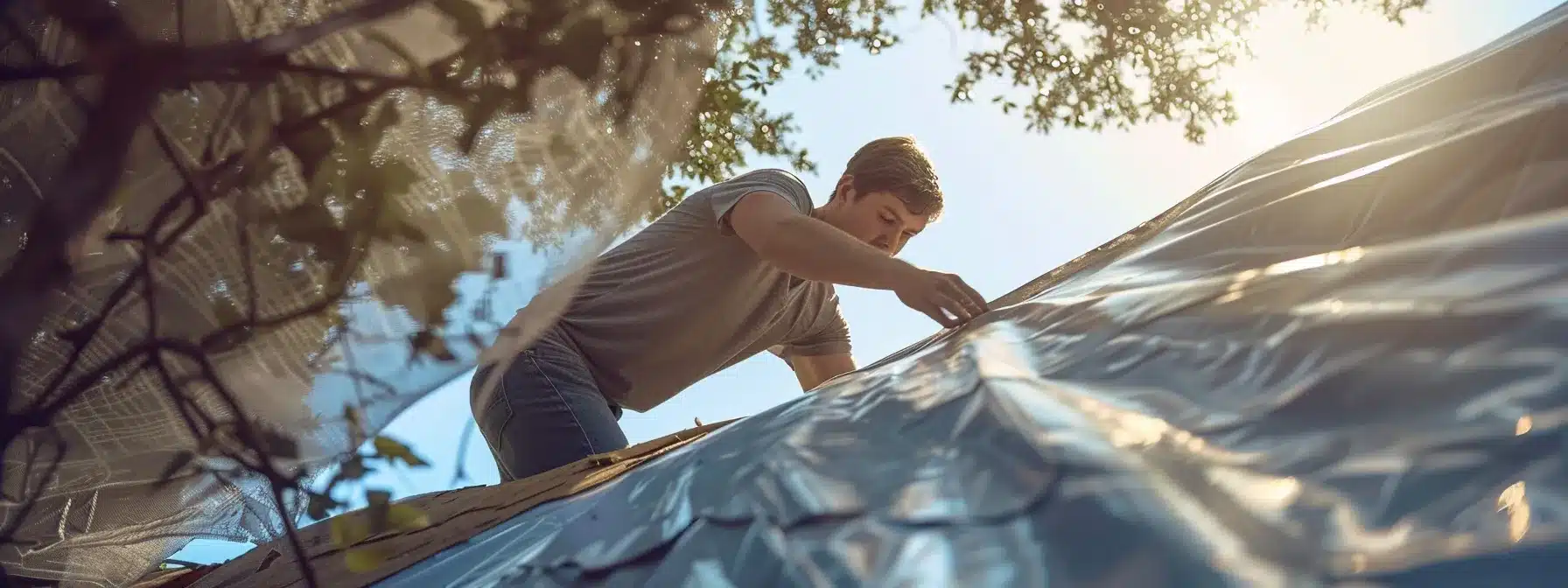 a homeowner in memphis carefully securing a tarp over a damaged roof to prevent further water damage.