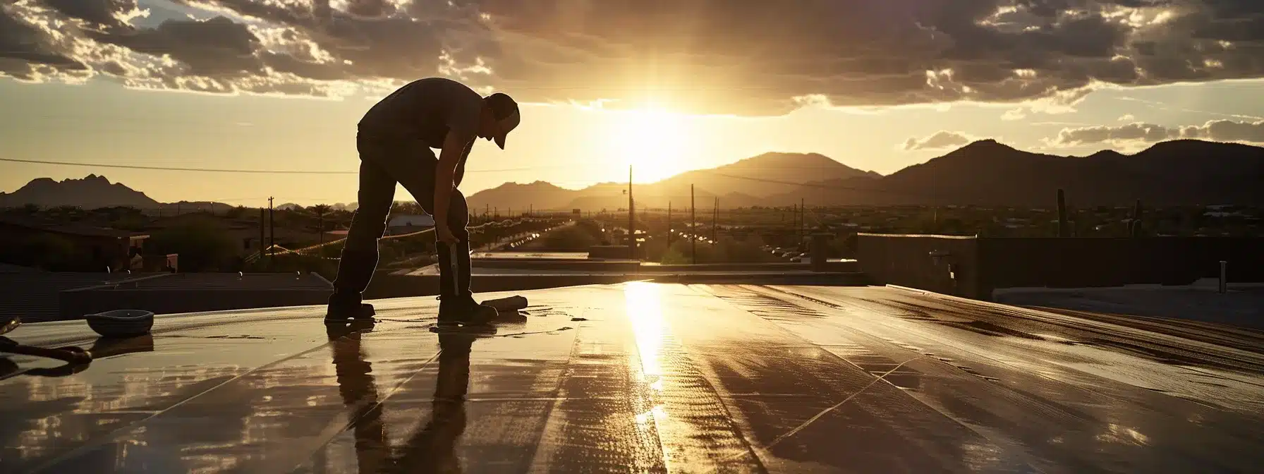 a skilled professional meticulously applies a glossy waterproofing solution to a sunlit, textured roof surface, showcasing the vibrant arizona landscape in the background.